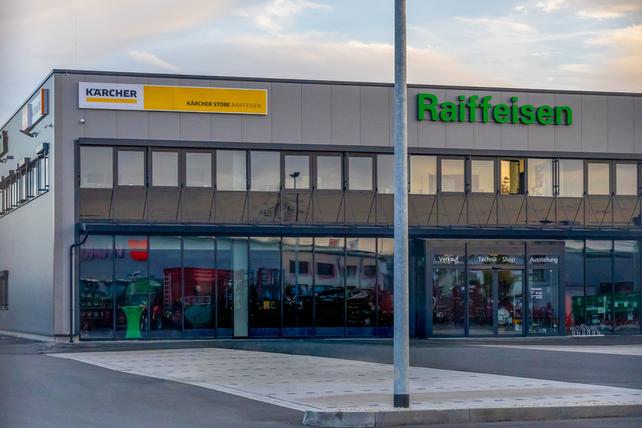 Außenansicht eines Raiffeisen-Gebäudes in Mitterteich mit mehreren Traktoren auf dem Hof; gebaut vom Hochbau der Firma Kassecker.